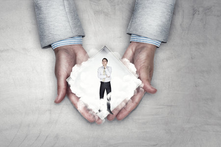 Small size businessman against dark backgroundの写真素材