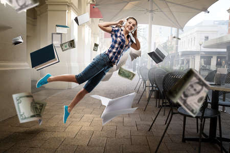 Woman wearing headphones jumping . Mixed mediaの写真素材