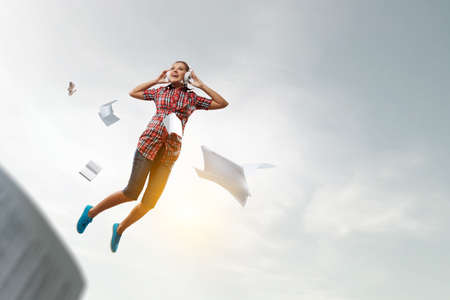 Woman wearing headphones jumping . Mixed media
