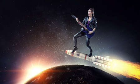 Young and beautiful rock girl playing the electric guitar