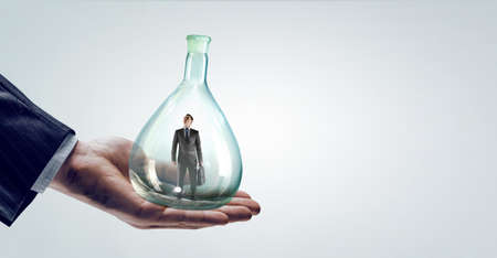 Business man standing inside a glass bottleの写真素材