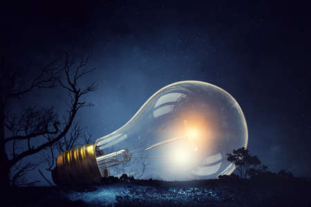 Huge light bulb glowing in the darkness