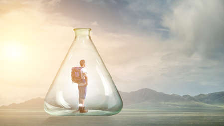 Young traveler inside glass bottleの写真素材