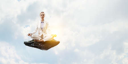 Business woman doing yoga in lotus poseの写真素材