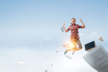 Woman wearing headphones jumping . Mixed mediaの写真素材