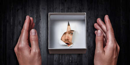 Male face through the hole in paper . Mixed media