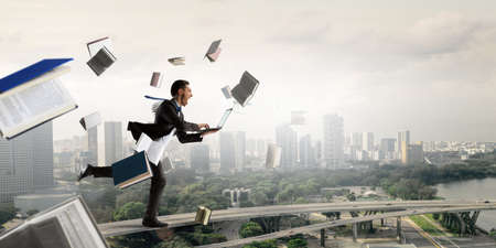 Happy businessman jumping high . Mixed mediaの写真素材