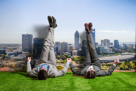 Couple of businessmen relaxing with their legs up on wall