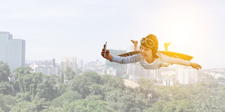 Happy little boy flying wearing helmetの写真素材