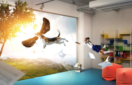 Girl with a dog flying through the air with his earsの写真素材