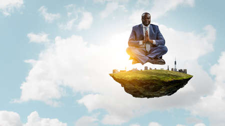 Young black man sitting and meditatingの写真素材