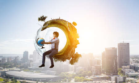 Young man holding a world globeの写真素材