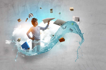 Happy kid playing with paper airplaneの写真素材