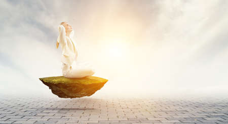 Business woman doing yoga in lotus poseの写真素材