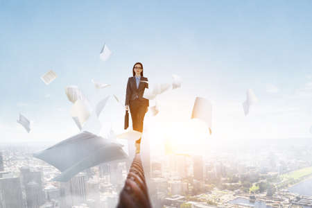 Image of businesswoman balancing on rope. Risk conceptの写真素材