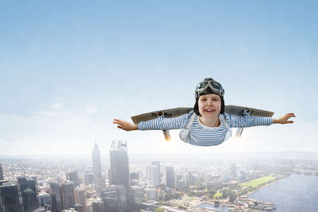 Happy little boy flying wearing helmetの写真素材