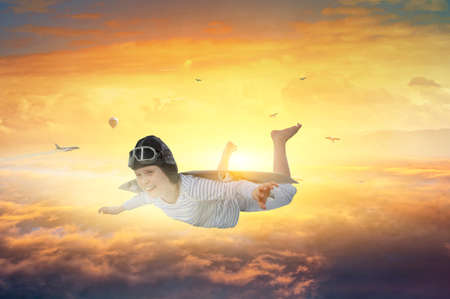 Happy little boy flying wearing helmetの写真素材