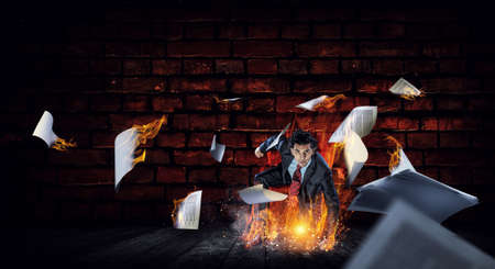 Determined businessman leaving fire trails on asphalt . Mixed mediaの写真素材