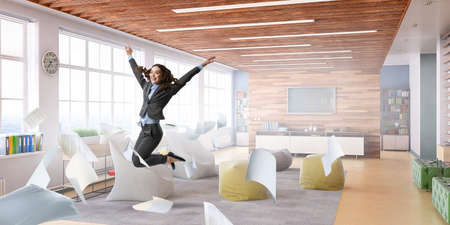 Portrait of energetic businesswoman jumping in open airの写真素材
