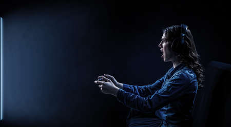 A woman in headphones with a controller set aside in her hands
