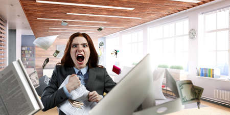 Young stressed woman ripping documents with frustrated facial expression.