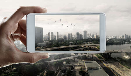 Hand holding smartphone mobile . Mixed mediaの写真素材