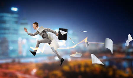 Portrait of energetic businessman jumping in open airの写真素材