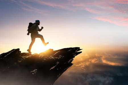 Male backpacker walking in mountains . Mixed mediaの写真素材