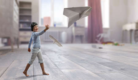 Happy kid playing with paper airplane . Mixed mediaの写真素材