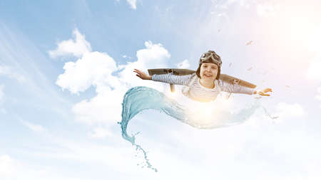 Happy little boy flying wearing helmet . Mixed mediaの写真素材