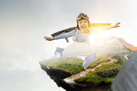 Happy little boy flying wearing helmet . Mixed mediaの写真素材