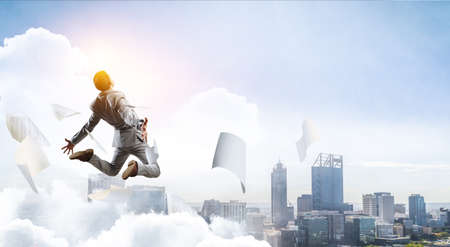 Portrait of energetic businessman jumping in open air . Mixed mediaの写真素材