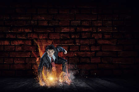 Determined businessman leaving fire trails on asphalt