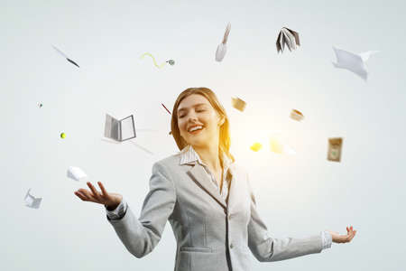 Young pretty businesswoman juggling with business itemsの写真素材