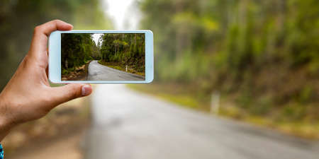 Hand holding smartphone mobile . Mixed mediaの写真素材