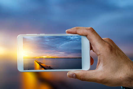 Hand holding smartphone mobile . Mixed mediaの写真素材