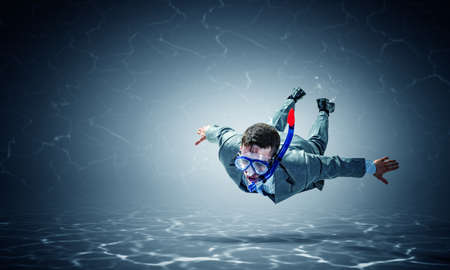 Young businessman in suit swimming