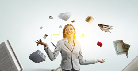 Young pretty businesswoman juggling with business itemsの写真素材