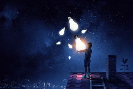 Boy with a glowing light bulbの写真素材