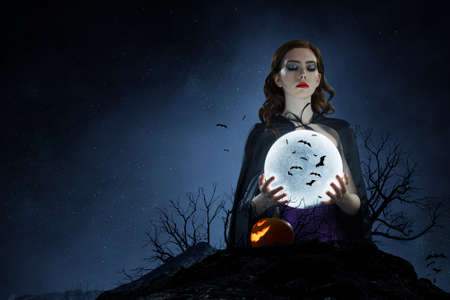 Beautiful young woman in witches hat and costume