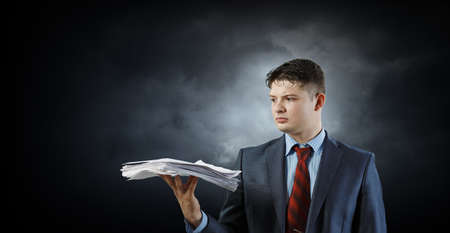 Business Concept - handsome young professional businessman holding report papers
