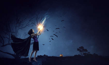 Beautiful young woman in witches hat and costume