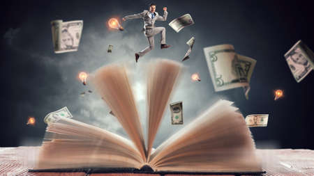 Businessman in suit running on top of a book