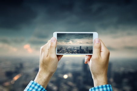 Hand holding smartphone mobile . Mixed mediaの写真素材