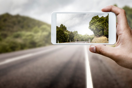 Hand holding smartphone mobile . Mixed mediaの写真素材