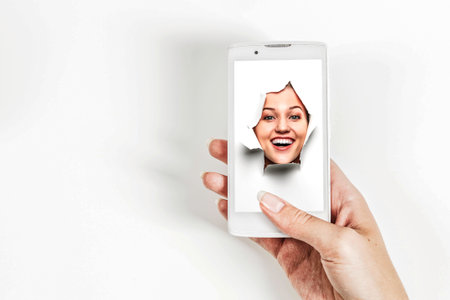 Female face through the hole in paperの写真素材