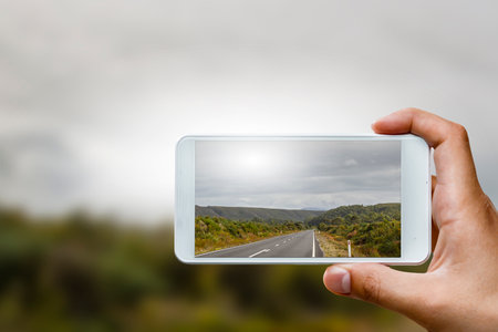 Hand holding smartphone mobile . Mixed mediaの写真素材