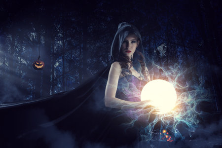 Beautiful young woman in witches hat and costumeの写真素材