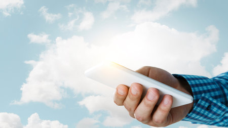 Hand with a smartphone on backgroundの写真素材