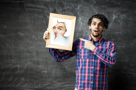 Male face through the hole in paperの写真素材